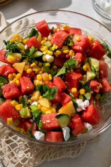 watermelon peach salad in a clear bowl.